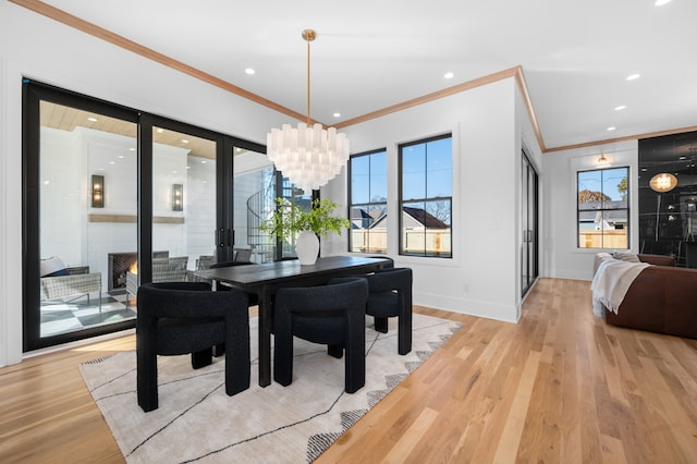 dining room with plenty of natural light, light wood-type flooring, and ornamental molding