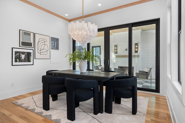 dining area featuring crown molding, light hardwood / wood-style floors, and a notable chandelier