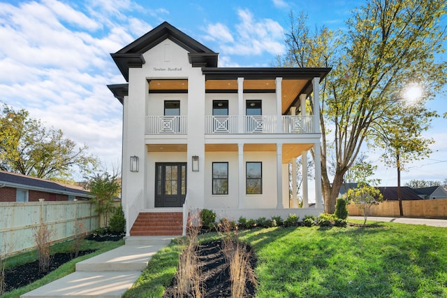 view of front of home with a front yard and a balcony