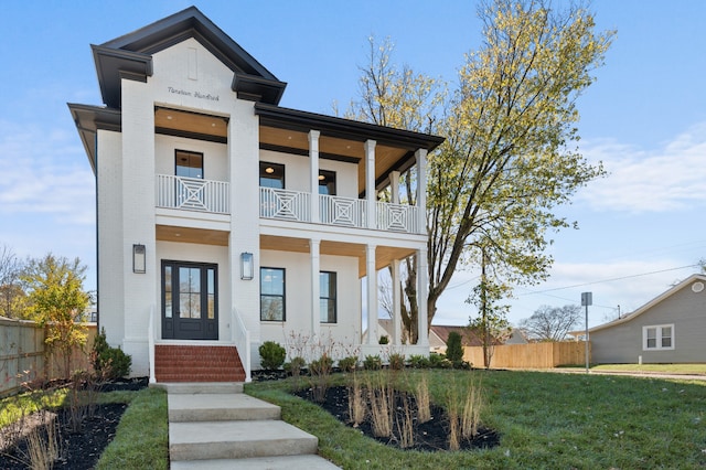 view of front of property featuring a front yard and a balcony