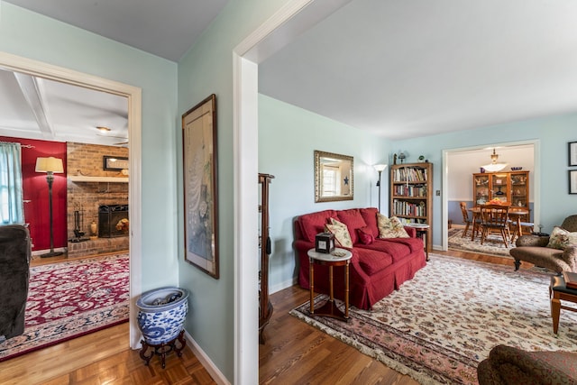 living room featuring hardwood / wood-style floors, a healthy amount of sunlight, and a brick fireplace