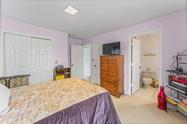 carpeted bedroom with a closet and ensuite bath