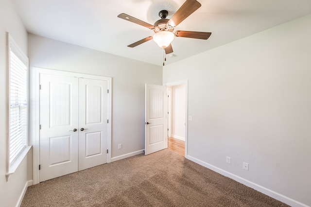 unfurnished bedroom with a closet, light carpet, and ceiling fan