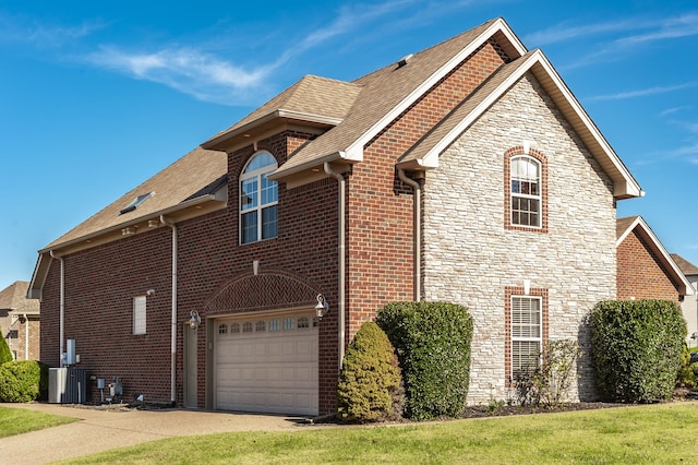 view of home's exterior with a garage and cooling unit