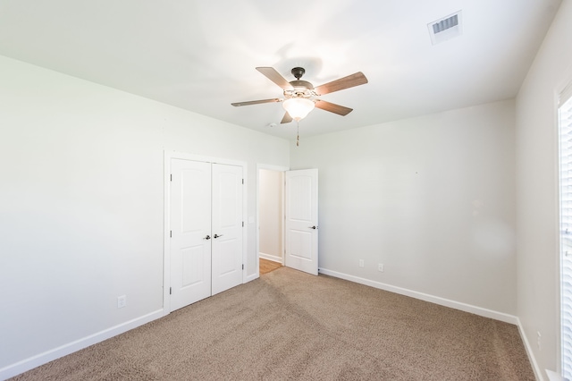 unfurnished bedroom featuring a closet, carpet, and ceiling fan