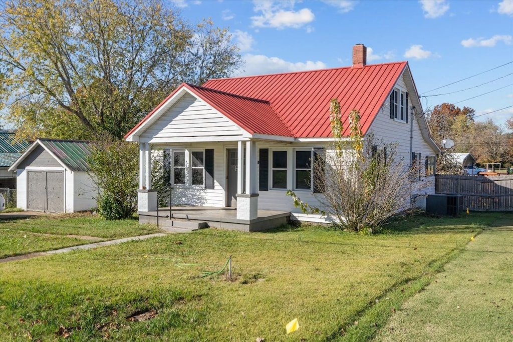 view of front of home with a front lawn, central air condition unit, and covered porch