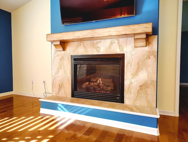 room details featuring hardwood / wood-style floors and a tiled fireplace