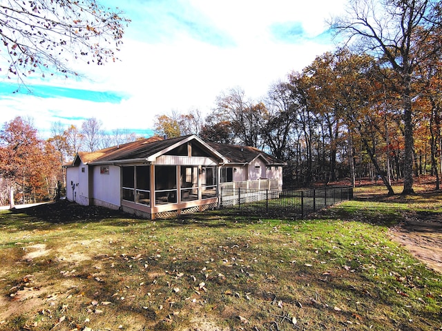 back of property featuring a sunroom and a yard