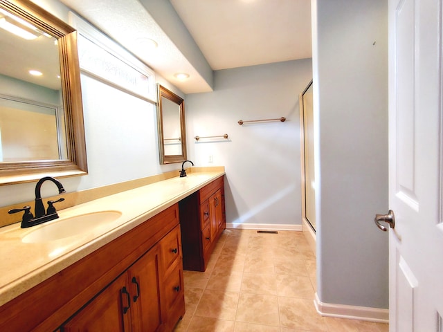 bathroom with walk in shower, vanity, and tile patterned flooring