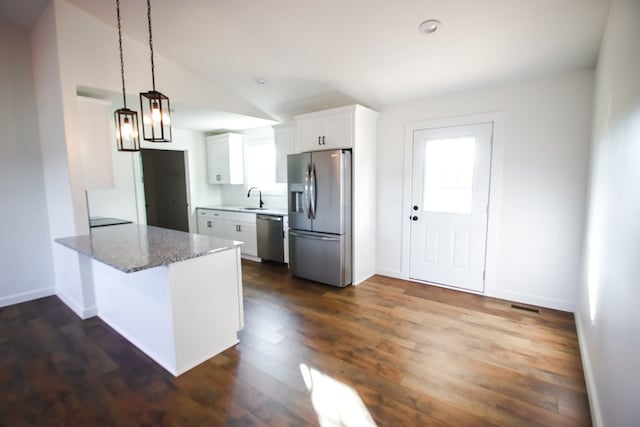 kitchen with stainless steel appliances, kitchen peninsula, dark hardwood / wood-style floors, stone counters, and white cabinets