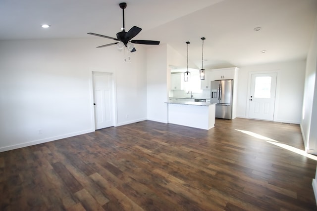 unfurnished living room with dark hardwood / wood-style flooring, ceiling fan, sink, and vaulted ceiling