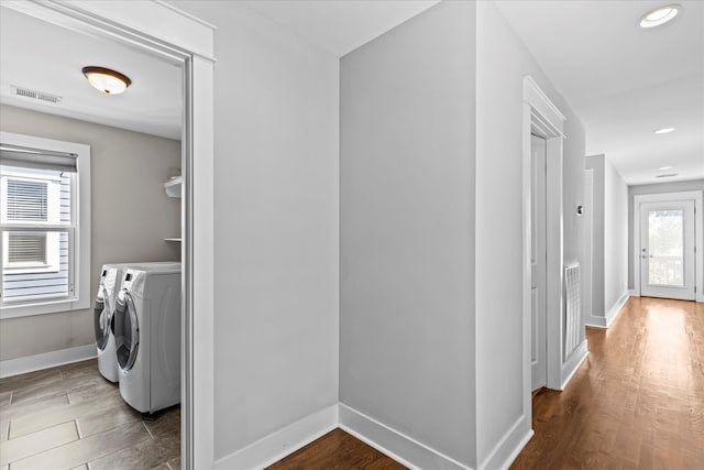 laundry area with dark hardwood / wood-style floors and washer and clothes dryer