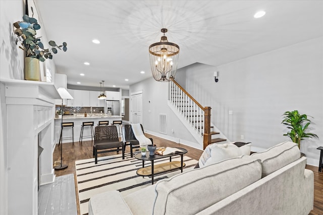 living room with light hardwood / wood-style floors and a notable chandelier