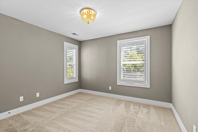 carpeted spare room featuring plenty of natural light