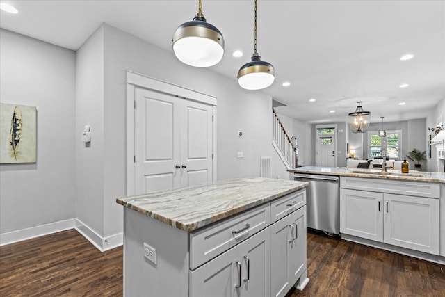 kitchen featuring dark hardwood / wood-style flooring, a center island, sink, stainless steel dishwasher, and pendant lighting