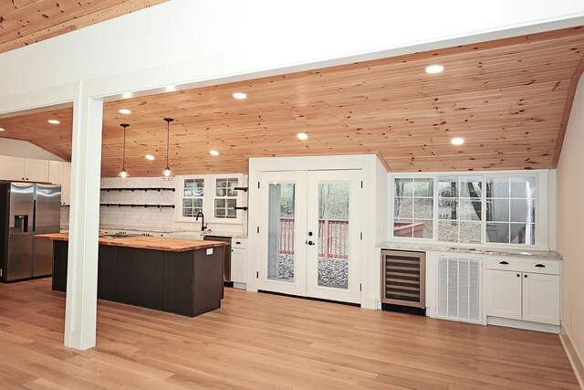 bar with stainless steel appliances, wooden ceiling, wooden counters, decorative light fixtures, and beverage cooler