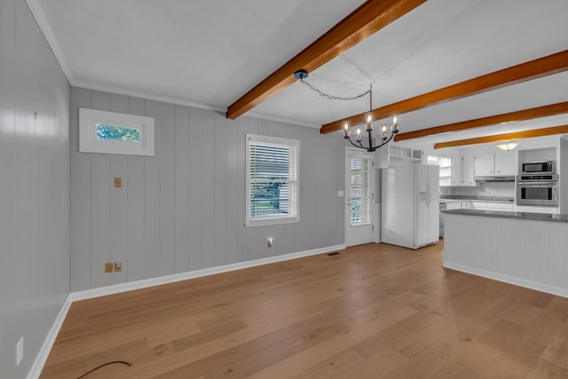 kitchen featuring appliances with stainless steel finishes, ornamental molding, beamed ceiling, light hardwood / wood-style floors, and white cabinetry