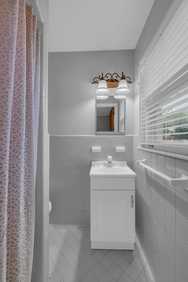 bathroom featuring tile patterned floors, vanity, and tile walls