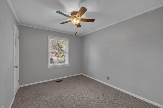 carpeted spare room featuring ceiling fan and crown molding