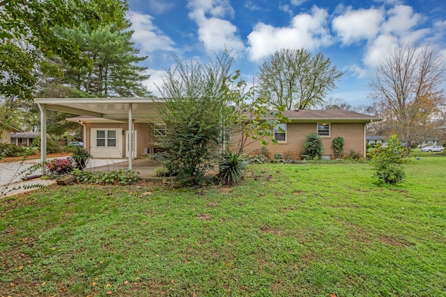 back of property featuring a lawn, a carport, and a patio