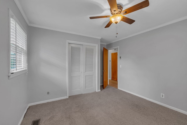 unfurnished bedroom with light colored carpet, a closet, ornamental molding, and ceiling fan