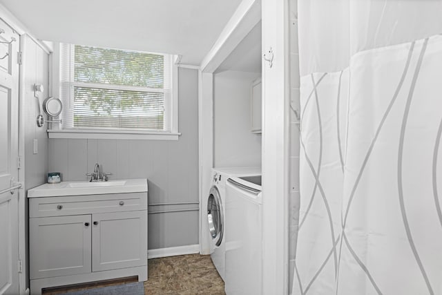 washroom featuring cabinets, separate washer and dryer, and sink