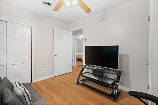 living room featuring ceiling fan and hardwood / wood-style flooring