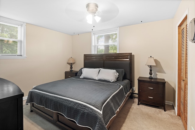 carpeted bedroom with ceiling fan and a closet