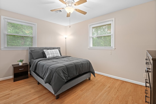 bedroom featuring multiple windows, ceiling fan, and light hardwood / wood-style flooring