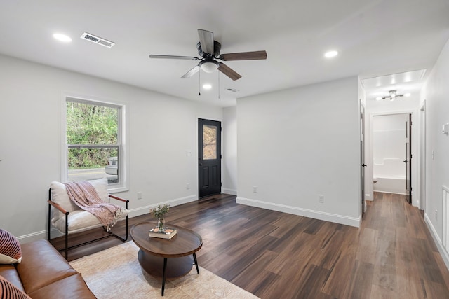 living room with ceiling fan and dark wood-type flooring