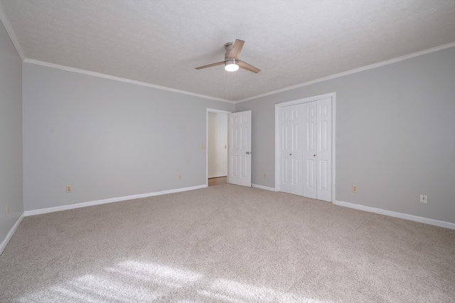 unfurnished bedroom featuring ornamental molding, ceiling fan, a textured ceiling, and carpet