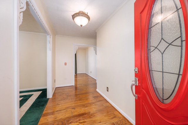 entryway with hardwood / wood-style floors and ornamental molding