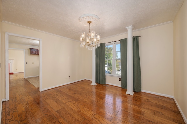 spare room with ornamental molding, wood-type flooring, a textured ceiling, and a notable chandelier