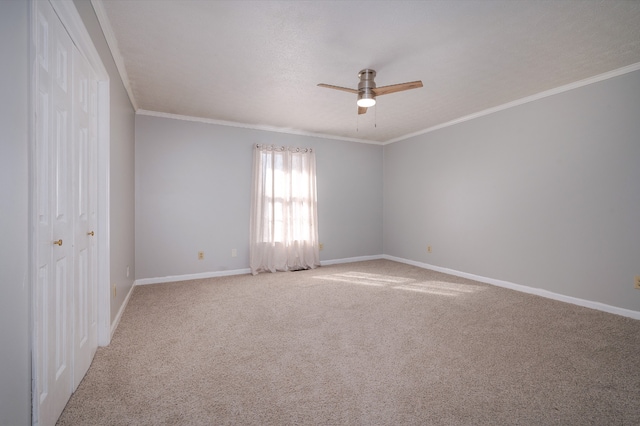 carpeted empty room with ceiling fan and ornamental molding