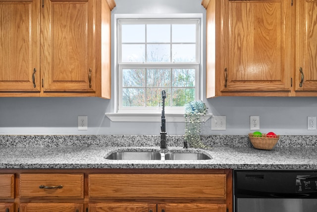 kitchen featuring sink, light stone counters, and dishwasher