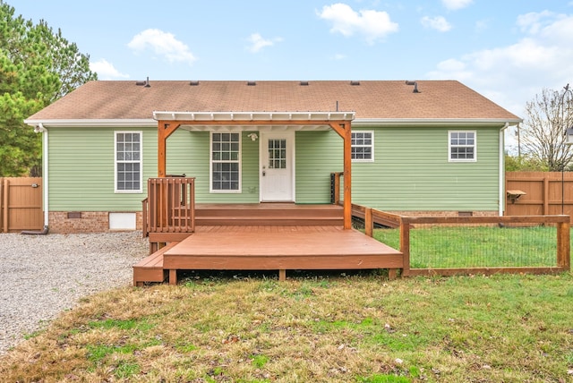 rear view of house featuring a lawn, a wooden deck, and a pergola