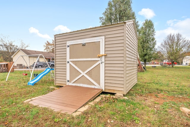 view of outbuilding featuring a playground and a yard