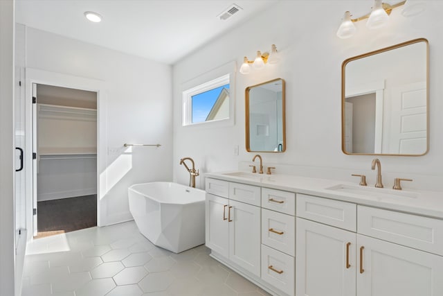 bathroom with tile patterned flooring, vanity, and a washtub