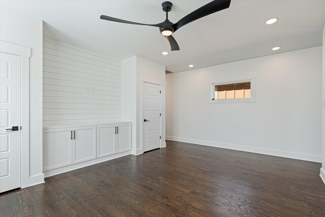 spare room with dark hardwood / wood-style flooring and ceiling fan