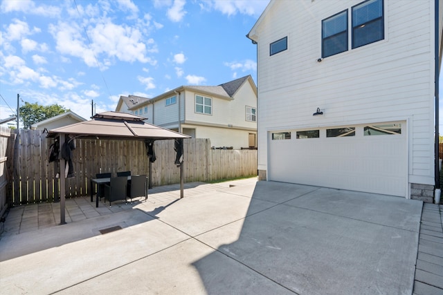 exterior space featuring a gazebo, a patio, and a garage