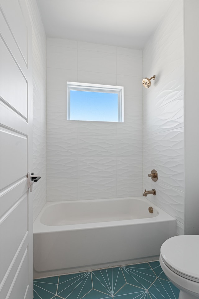 bathroom with tile patterned floors, tiled shower / bath, and toilet