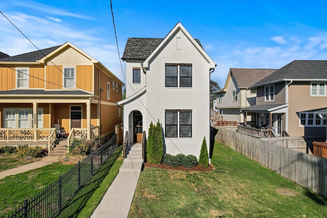 view of front of house with covered porch and a front lawn