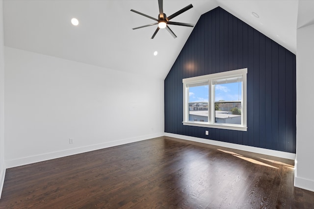 additional living space featuring lofted ceiling, wooden walls, ceiling fan, and dark wood-type flooring