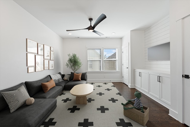 living room with ceiling fan and dark hardwood / wood-style flooring