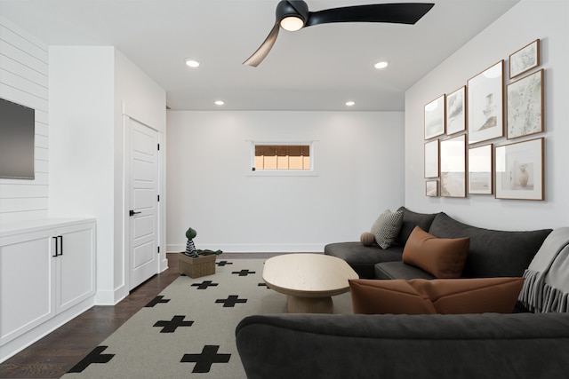 living room with ceiling fan and dark wood-type flooring