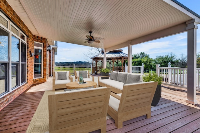 wooden terrace with ceiling fan, outdoor lounge area, and a gazebo