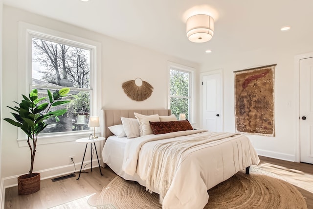 bedroom featuring hardwood / wood-style floors and multiple windows