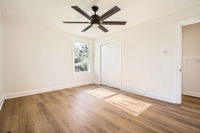 unfurnished bedroom featuring a closet, hardwood / wood-style flooring, and ceiling fan