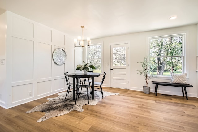 dining area featuring light hardwood / wood-style floors and a chandelier