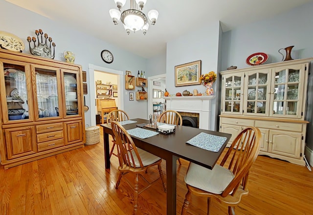 dining area with a chandelier and light hardwood / wood-style flooring